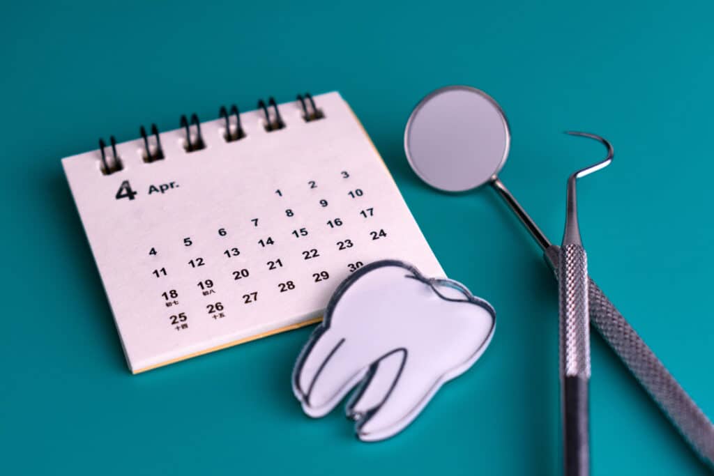 Orthodontic appointment concept with calendar and dental instruments.