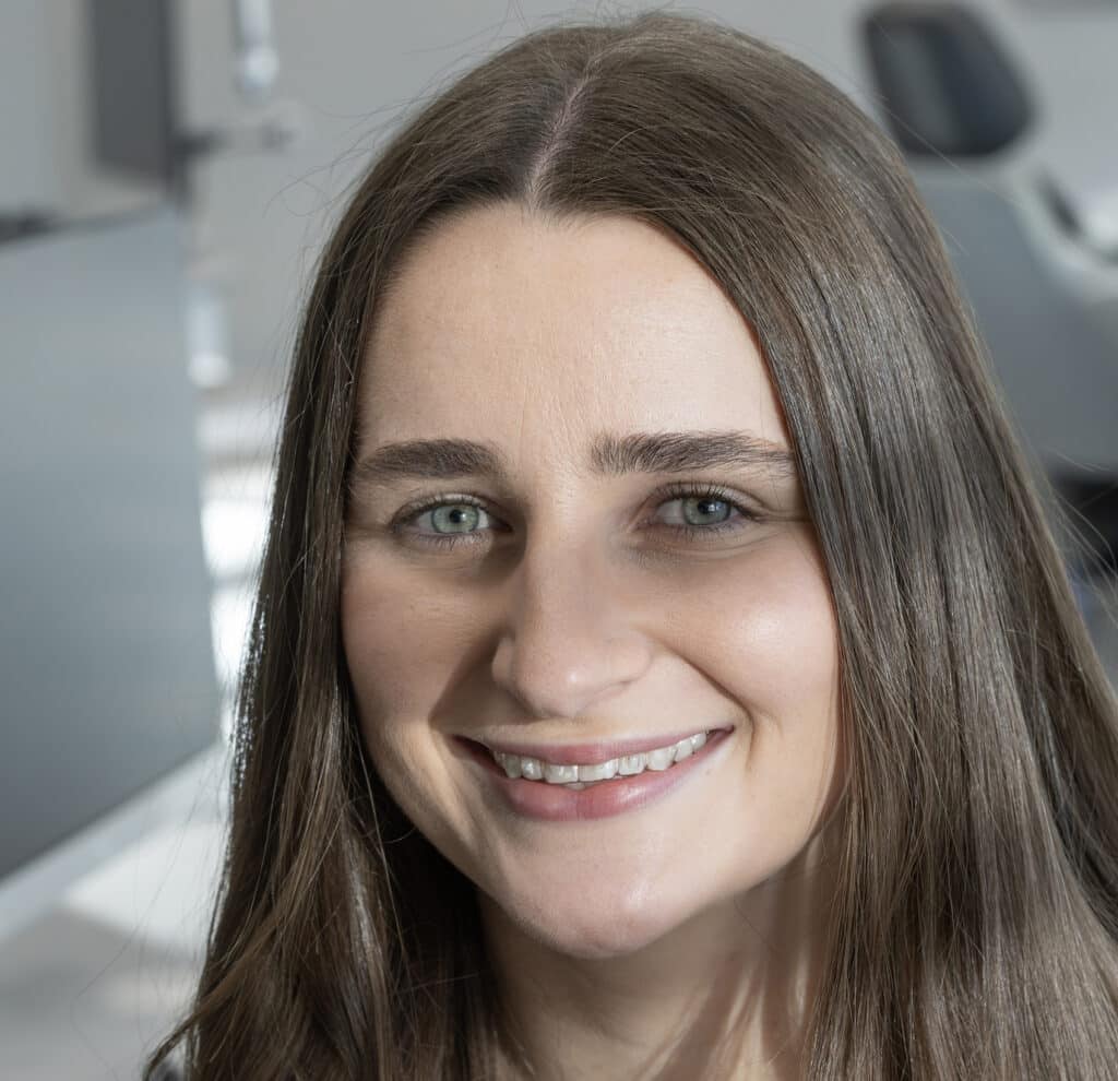 Woman wearing clear aligners with attachments.