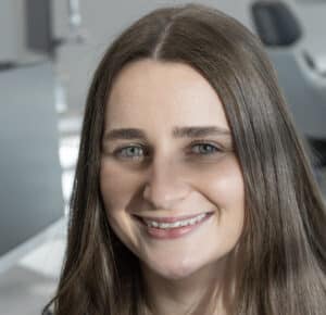 Woman wearing clear aligners with attachments.