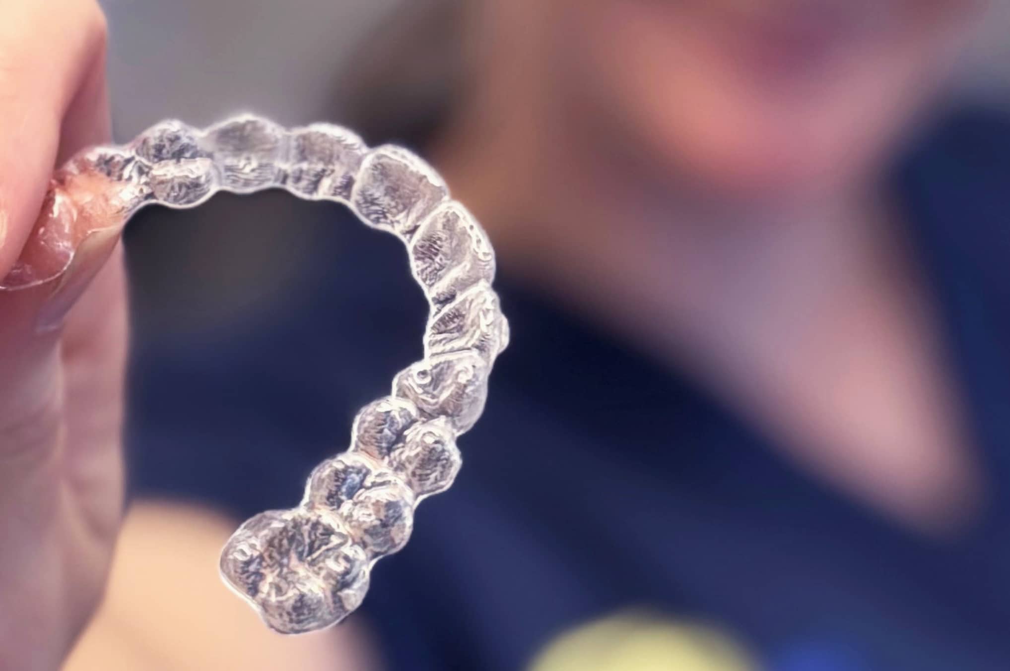 Invisalign aligner held by Fine Orthodontist Sydney staff member.