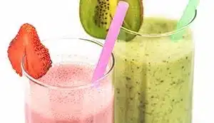 Two fruit smoothies pictured side-by-side - one pink and one green.