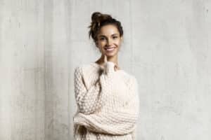 Woman thinking, deciding between Invisalign versus veneers.