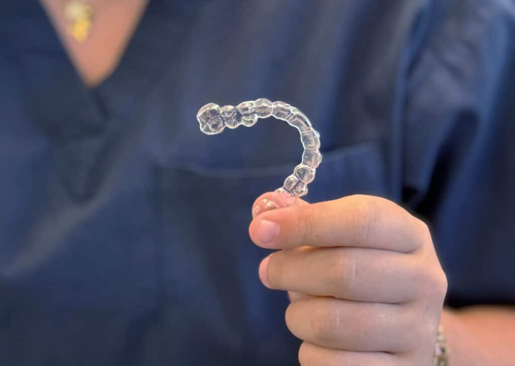 Invisalign aligner held by Fine Orthodontist Sydney staff.