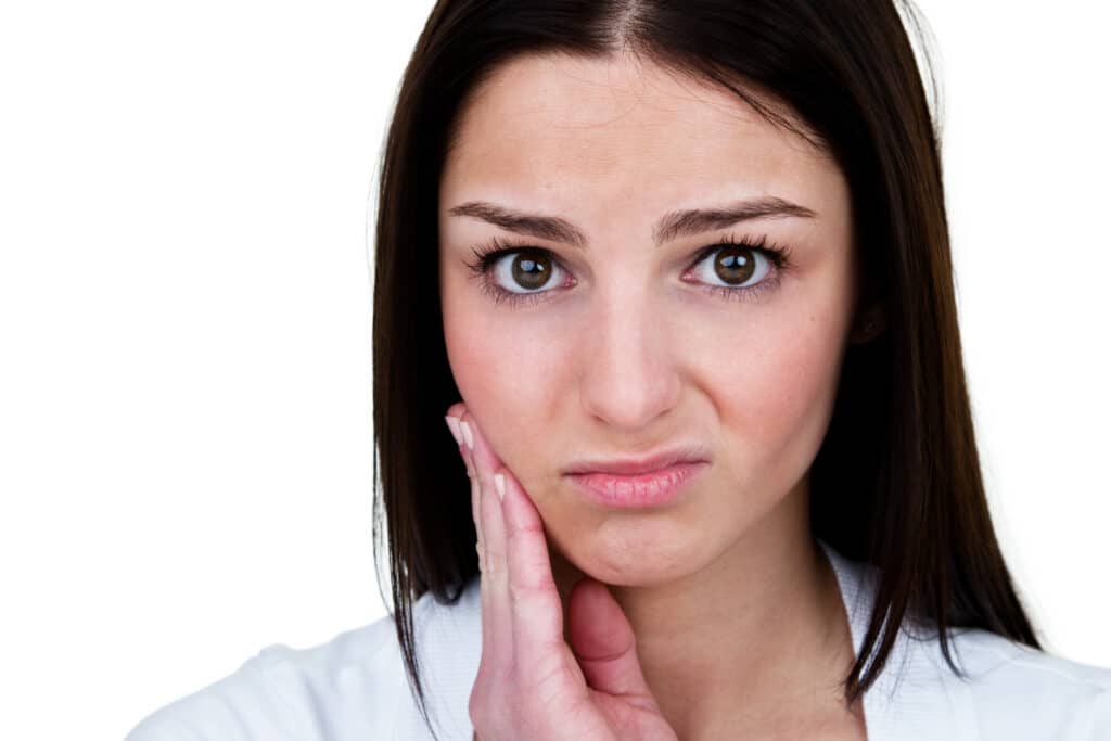 Girl with hand on the side of her face wondering if Invisalign is uncomfortable.