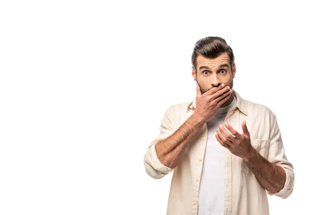 Braces breakage - surprised man looking at camera and covering mouth.