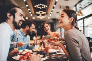 Group of people pictured out and about eating during Invisalign treatment.