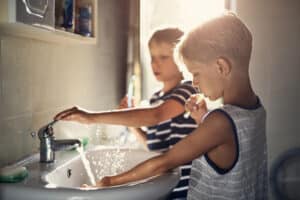 Caring for chalky teeth - Two boys aged 8 are brushing teeth together in a bathroom.