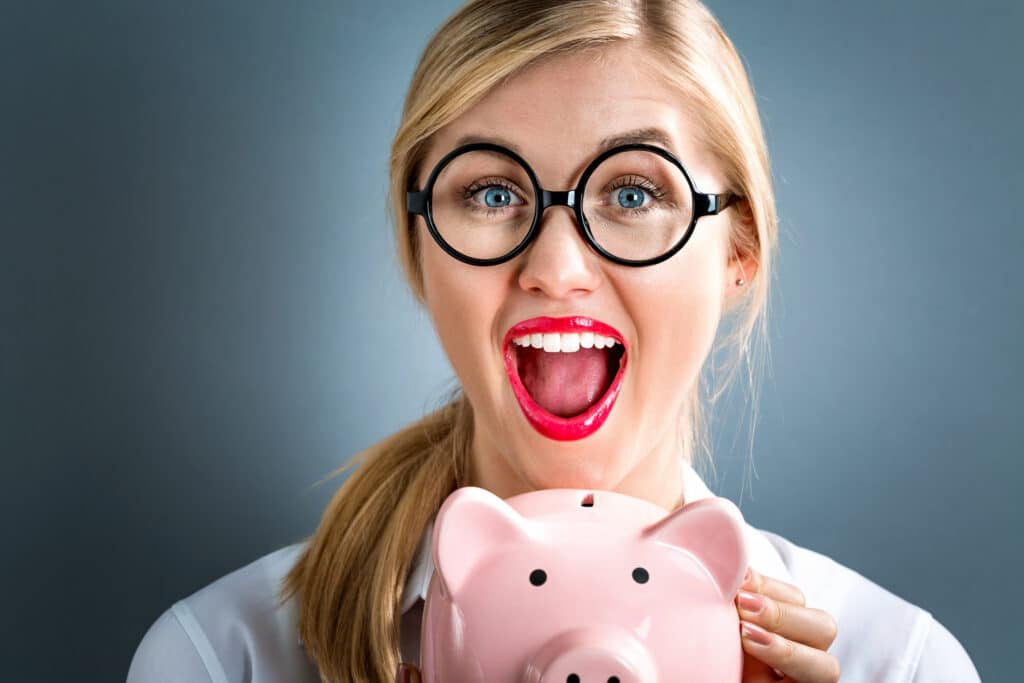 Young woman wondering if medicare covers braces, holding a piggybank.